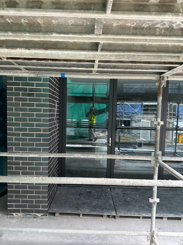 Installed window behind exterior scaffolding on an Australian building