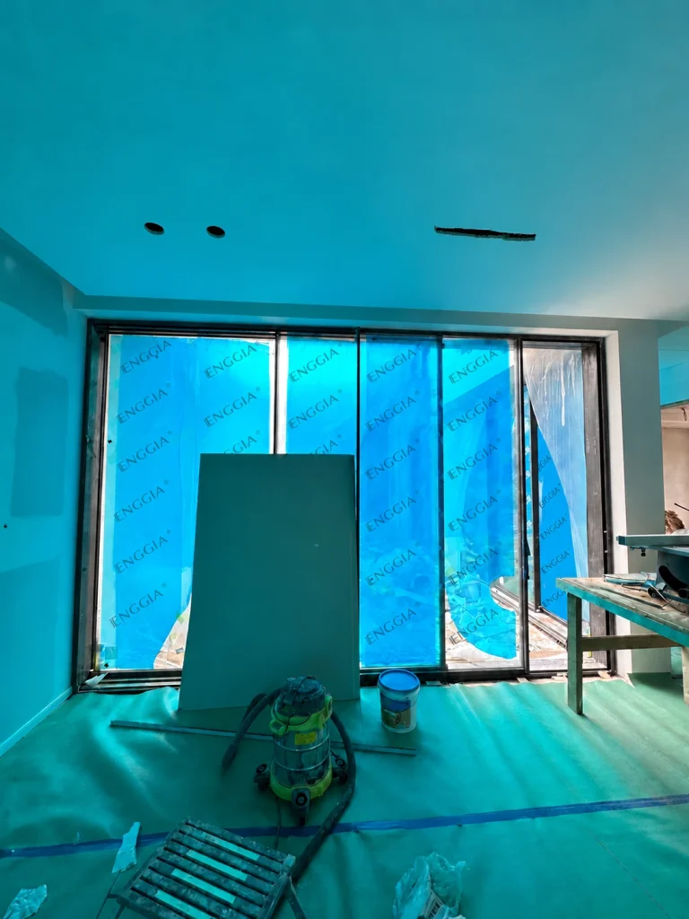 Glazed doors, tools and protective film inside an Australian home under construction
