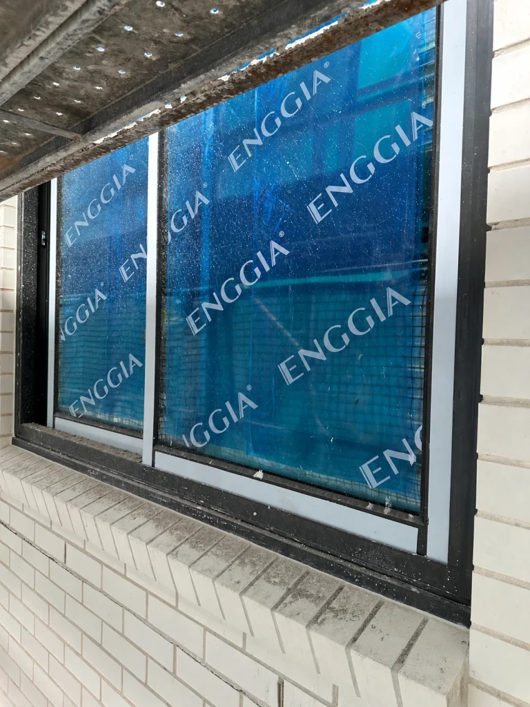 Protected glazing in a brick wall during construction