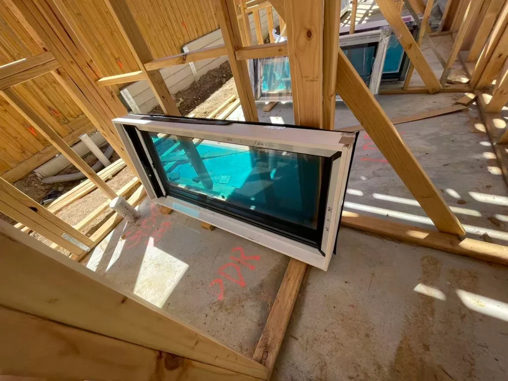 Protected glazing staged beside the timber wall framing